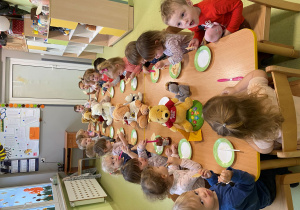 Dzieci siedzą przy stole i degustują przysmak Misia.