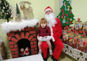 Zuzia pozuje do zdjęcia ze Świętym Mikołajem.