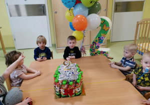 Eldar z dziećmi siedzi przy urodzinowym stole.