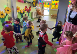 Dzieci bawią się i tańczą przy dziecięcych utworach.