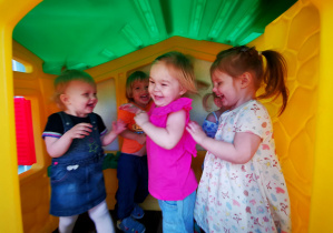 Dzieci bawią się w domku na tarasie.