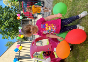 Ala pozuje do zdjęcia z kolorowymi balonami.