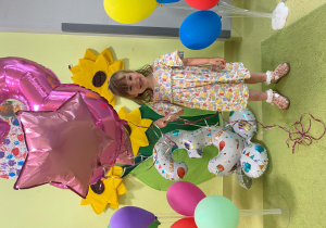 Hania stoi i pozuje z urodzinowymi balonami.