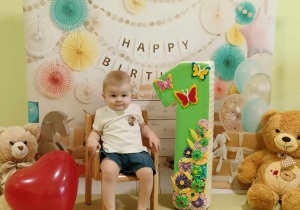 Tobiasz pozuje do urodzinowego zdjęcia z okazji pierwszych urodzin.