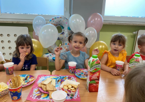 Dzieci siedzą przy stole i świętują urodziny Poli.