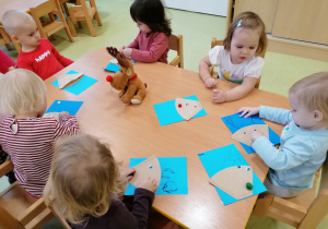 Dzieci siedzą przy stoliku i wykonujemy pracę plastyczną "Renifer".