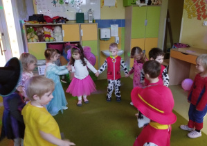 Dzieci tańczą w kółku.