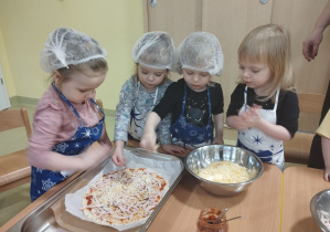 Dzieci wspólnie robią pizzę.