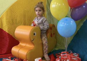 Nadia siedzi na bujaku i trzyma w ręku prezent.