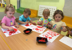 Dzieci malują farbami serduszka z masy solnej.