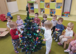 Gabrysia i Róża ubierają choinkę.