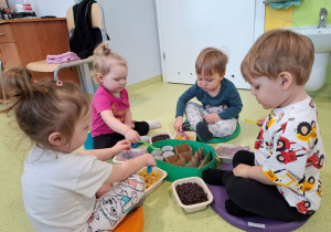 Dzieci tworzą sensoryczną pisankę.