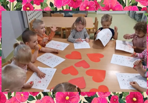 Dzieci kolorują kwiatki do laurek dla rodziców.