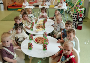 Dzieci siedzą przy stole i świętują urodziny Hani.