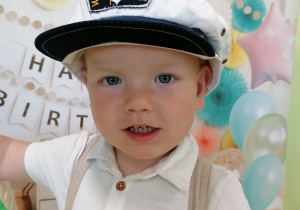 Nicolas w czapce kapitana pozuje do zdjęcia.