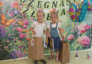 Jan i Karolina pozują do zdjęcia z prezentami z okazji zakończenia żłobka.