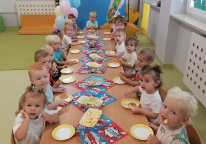 Dzieci siedzą przy stolikach i świętują urodziny Mateusza.