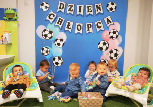 Dzieci pozują do pamiątkowego zdjęcia z prezentami.