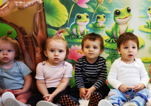 Tadej z dziećmi siedzi na dywanie i pozuje do wspólnego pamiątkowego zdjęcia.