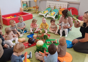 Dzieci słuchają opowiadanych treści o różnych warzywach.