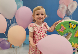 Julia pozuje do zdjęcia z kolorowymi balonami.