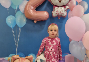 Ania z kolorowymi balonami pozuje do urodzinowego zdjęcia.