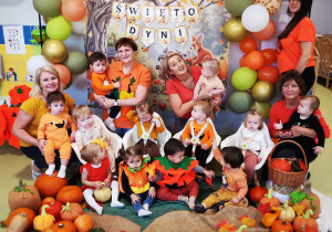 Dzieci z opiekunkami pozują do wspólnego pamiątkowego zdjęcia.