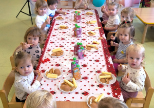 Dzieci siedzą przy stole i jedzą słodki poczęstunek przygotowany przez rodziców Lavrentiego.