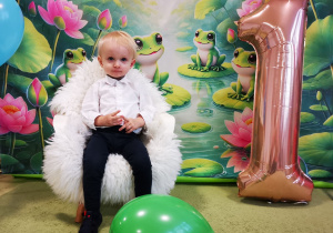 Leon siedzi na krześle, pozuje do pamiątkowego zdjęcia.