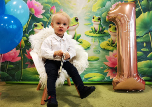 Leon siedzi na krześle, pozuje do pamiątkowego zdjęcia.