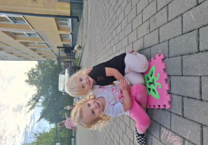 Jagna i Oliwka pozują do zdjęcia podczas zabawy na dworze.