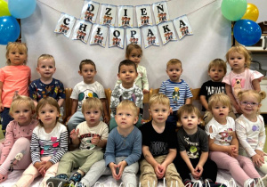 Chłopcy pozują do pamiątkowego zdjęcia z okazji Dnia Chłopca.