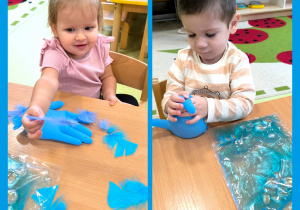 Dzieci siedzą przy stoliku i bawią się niebieskimi, gumowymi rękawiczkami wypełnionymi wodą.