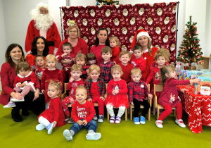 Zdjęcie grupowe. dzieci wraz z opiekunkami i Św. Mikołajem pozują do wspólnego zdjęcia.