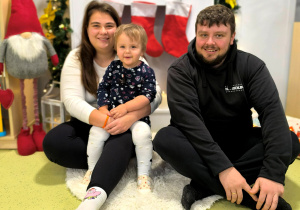 Julia z rodzicami pozuje do świątecznego zdjęcia.