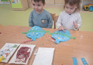 Leon i Lila dekorują papierowe bombki.