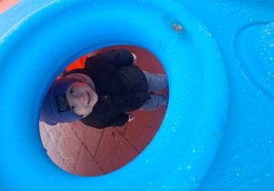 Bartosz pozuje do zdjęcia podczas zabawy na placu zabaw.