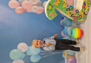 Mikołaj pozuje na urodzinowym tle.