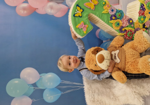 Mikołaj z pluszowym pieskiem i cyfrą 2 pozuje do urodzinowego zdjęcia.