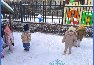 Dzieci bawią się na śniegu na placu zabaw.