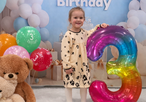 Hania pozuje do pamiątkowego zdjęcia z okazji urodzin.