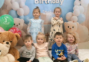 Dzieci pozują do pamiątkowego zdjęcia z okazji urodzin dziewczynek.