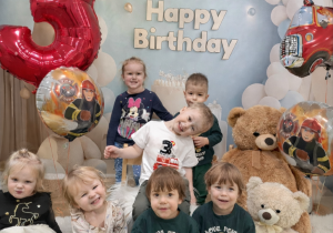Dzieci pozują do pamiątkowego zdjęcia z okazji urodzin.