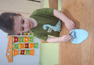 Franek wycina serduszko z ciasta za pomocą foremki.