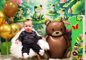 Leoś siedzi na krzesełku, pozuje do urodzinowego zdjęcia.