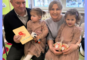 Amelka i Julia siedzą u dziadków na kolanach.