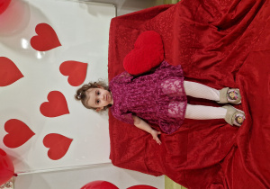 Roksana na tle czerwonych serc pozuje do walentynkowego zdjęcia.