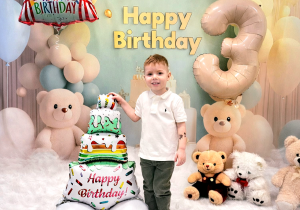 Stasio pozuje do pamiątkowego zdjęcia z okazji urodzin.