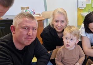 Szymon z rodzicami pozuje do zdjęcia podczas Warsztatów Wielkanocnych.