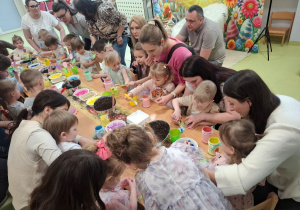 Dzieci wraz z rodzicami tworzą piękne, kolorowe kwiaty.